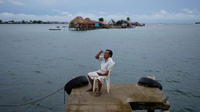 Evelio Lopez tries to get cell phone connection on a dock on Gardi Sugdub Island, part of the San Blas archipelago off Panama's Caribbean coast, 25 May 2024. 