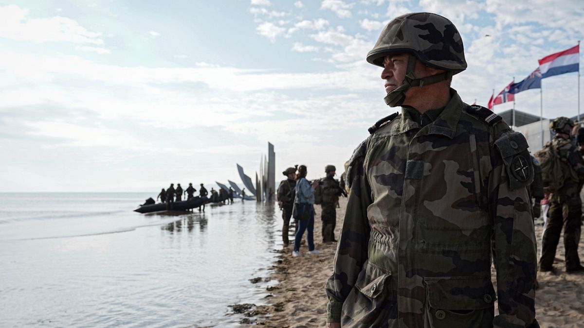 جندي فرنسي ينظر إلى القوات البحرية الأمريكية والفرنسية أثناء أداء بروفة هجوم برمائي على شاطئ أوماها، فرنسا، في 4 يونيو 2024