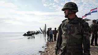 A French soldier looks on as U.S. and French Naval Forces perform an amphibious assault rehearsal on OMAHA Beach, France, on 4th June 2024