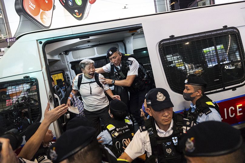 Agentes de policía detienen a un residente en la zona de Causeway Bay en el 35º aniversario de la represión china en la plaza de Tiananmen, en Hong Kong, el martes 4 de junio.