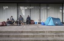 Бездомные с палаткой рядом с витриной