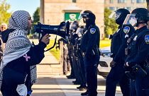  معترضان در مقابل افسران پلیس دیترویت از ایالت وین آمریکا، اندکی پس از آنکه مقامات دانشگاه یک تحصن در حمایت از فلسطینیان را در تاریخ ۳۰ مه از محوطه دانشگاه برچیدند