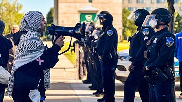  معترضان در مقابل افسران پلیس دیترویت از ایالت وین آمریکا، اندکی پس از آنکه مقامات دانشگاه یک تحصن در حمایت از فلسطینیان را در تاریخ ۳۰ مه از محوطه دانشگاه برچیدند