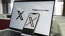 The opening page of X is displayed on a computer and phone, Oct. 16, 2023, in Sydney.