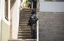 Ein Polizeibeamter steht mit einer Maschinenpistole vor einer Tür in Althengstett, Deutschland, Dienstag, 4. Juni 2024. 