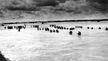 In this June 1944, file photo, U.S. reinforcements wade through the surf as they land at Normandy.