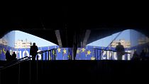 Мужчина идет к предвыборному баннеру у здания Европейского парламента в Брюсселе. Европейские выборы пройдут с 6 по 9 июня.