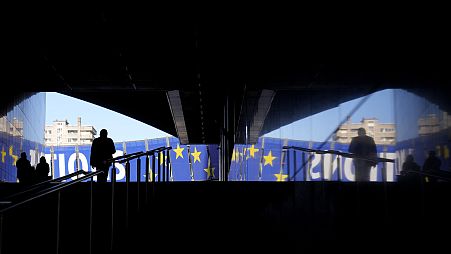 A man walks toward an election banner outside the European Parliament in Brussels on Monday, April 29, 2024. The European Elections will take place from June 6 to June 9, 2024