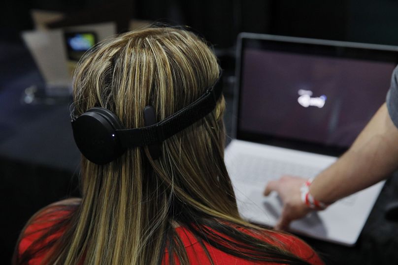 Bir kadın, CES Unveiled 2020 sırasında NextMind standında NextMind eller serbest beyin-bilgisayar arayüz cihazını kullanıyor.