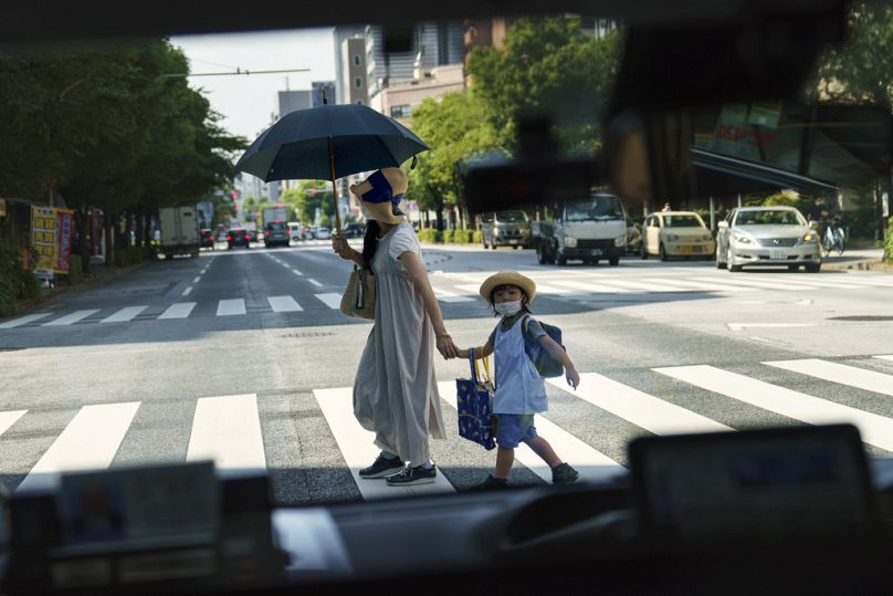 Japonya'nın başkenti Tokyo'da yaya gecinde bir kadın ve çocuk