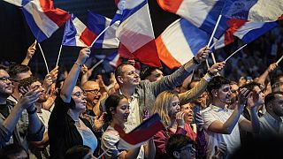 Sostenitori del National Rally, partito di estrema destra, sventolano bandiere durante un incontro per le prossime elezioni europee a Henin-Beaumont, nel nord della Francia, venerdì 24 maggio 2024. 