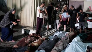 فلسطينيون يبكون ذويهم الذين قتلوا في قصف إسرائيلي لمدرسة تابعة للأونروا في مخيم النصيرات، أمام مستشفى شهداء الأقصى في دير البلح. الخميس 6 حزيران / يونيو 2024.
