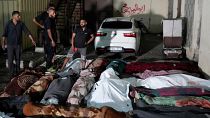 Palestinians mourn their relatives killed in an Israeli bombardment of the UNRWA school at Nusseirat refugee camp, in front of the morgue of al-Aqsa Martyrs hospital.