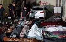Palestinians mourn their relatives killed in an Israeli bombardment of the UNRWA school at Nusseirat refugee camp, in front of the morgue of al-Aqsa Martyrs hospital.