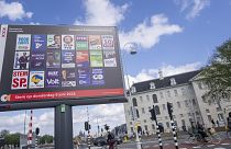 Ποδηλάτες προσπερνούν μια διαφημιστική πινακίδα για τις ευρωπαϊκές εκλογές έξω από το Ναυτικό Μουσείο στο Άμστερνταμ, Ολλανδία, Τετάρτη 5 Ιουνίου 2024.