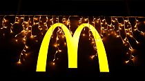 Luces navideñas cuelgan sobre el logotipo fuera de un restaurante McDonald's en Lisboa, el martes 14 de diciembre de 2021. (AP Photo/Armando Franca)