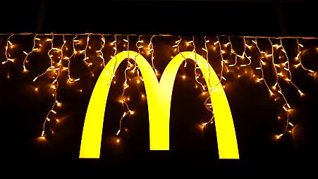 Christmas lights are hung above the logo outside a McDonald's restaurant in Lisbon, Tuesday, Dec. 14, 2021. (AP Photo/Armando Franca)