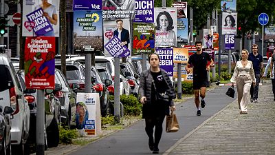 Un grupo de personas pasa junto a los carteles de las elecciones europeas en Fráncfort, el 6 de junio de 2024.