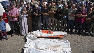 Un grupo de palestinos reza por los muertos en un bombardeo israelí sobre Gaza, en un hospital de la localidad de Deir al Balah este viernes.