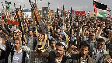 Houthi supporters shout slogans as they raise machine-guns and Palestinian flags during a rally against the U.S.-led strikes against Yemen.Friday, May 17, 2024. 