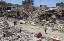 Palestinians walk through the destruction in the wake of an Israeli air and ground offensive in Jebaliya, northern Gaza Strip in May.
