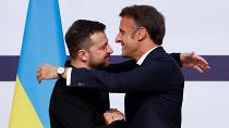 French President Emmanuel Macron, right, hugs Ukrainian President Volodymyr Zelenskyy during a joint press conference, Friday, June 7, 2024 