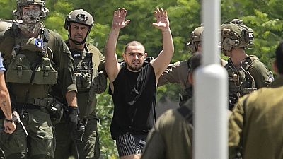 Almog Meir Jan, 21, kidnapped from Israel in a Hamas-led attack on Oct. 7, 2023, raises his hands after arriving by helicopter to the Sheba Medical Center in Ramat Gan, Israel