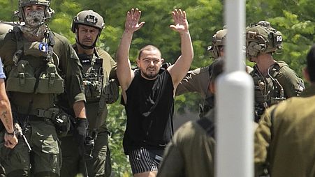 Almog Meir Jan, 21, kidnapped from Israel in a Hamas-led attack on Oct. 7, 2023, raises his hands after arriving by helicopter to the Sheba Medical Center in Ramat Gan, Israel
