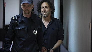 El ciudadano francés Laurent Vinatier, a la derecha, es escoltado a una jaula en una sala del tribunal del distrito de Zamoskvoretsky en Moscú, Rusia, el viernes 7 de junio de 2024.