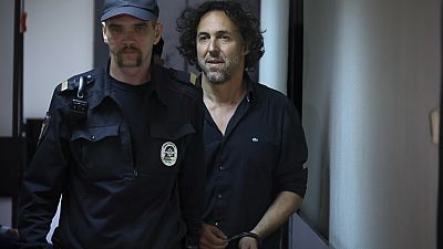 El ciudadano francés Laurent Vinatier, a la derecha, es escoltado a una jaula en una sala del tribunal del distrito de Zamoskvoretsky en Moscú, Rusia, el viernes 7 de junio de 2024.