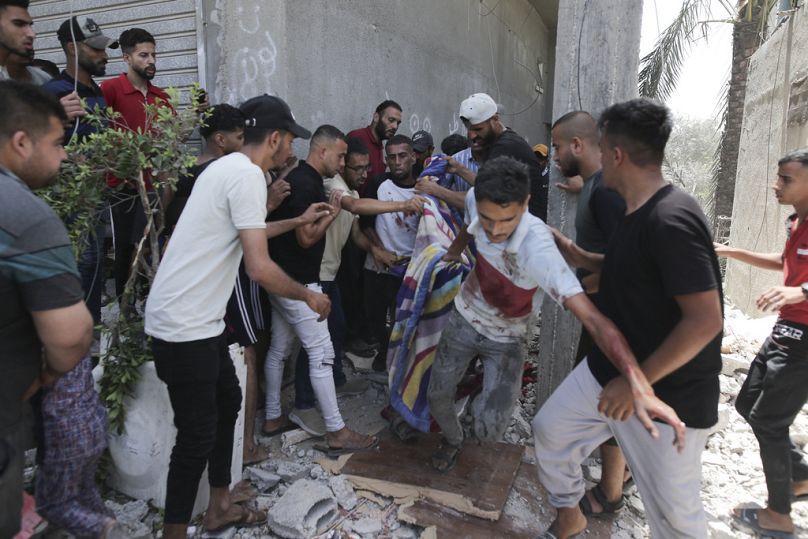 Des Palestiniens évacuent les morts et les blessés lors du bombardement israélien de la bande de Gaza à Deir al Balah, le samedi 8 juin 2024.