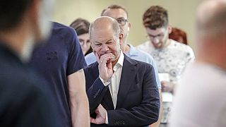 German Chancellor Olaf Scholz waits in line to cast his vote for the European Parliament elections, in Potsdam, Germany, Sunday, June 9, 2024. 