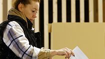 Una mujer deposita su voto para las elecciones en un colegio electoral de Liubliana, Eslovenia.