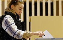 Una mujer deposita su voto para las elecciones en un colegio electoral de Liubliana, Eslovenia.