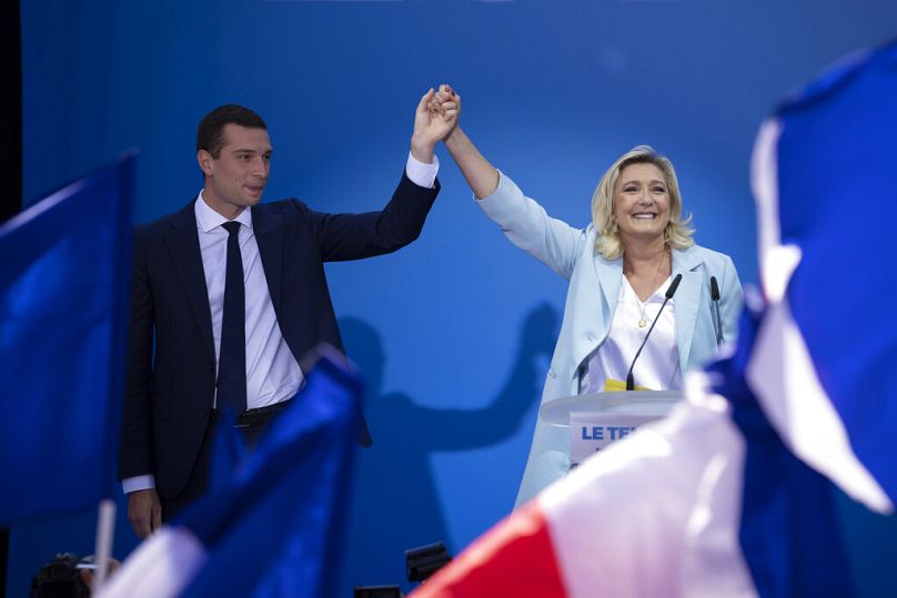Jordan Bardella, left, and Marine Le Pen salute the crowd at a National Rally event in Frejus, France