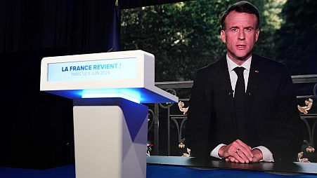 Le président français Emmanuel Macron apparaît sur un écran de télévision au siège du parti d'extrême droite du Rassemblement national lors de la soirée électorale, le dimanche 9 juin 2024 à Paris.