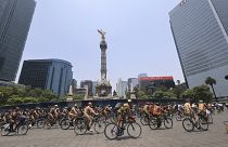 Cyclists pedal by the Angel of Independence monument marking World Naked Bike Ride day, in Mexico City