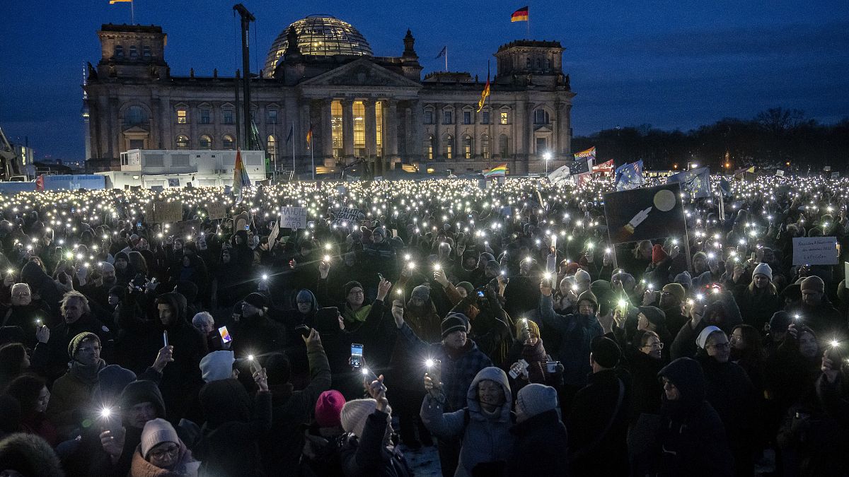 أشخاص يرفعون هواتفهم المحمولة أثناء احتجاجهم على حزب البديل من أجل ألمانيا اليميني المتطرف.