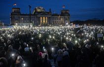 أشخاص يرفعون هواتفهم المحمولة أثناء احتجاجهم على حزب البديل من أجل ألمانيا اليميني المتطرف.