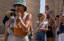 Os turistas visitam a antiga Acrópole.