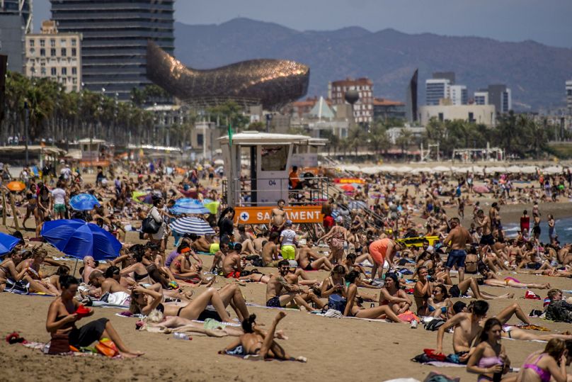 Menschen beim Sonnenbaden am Strand von Barcelona, Spanien.