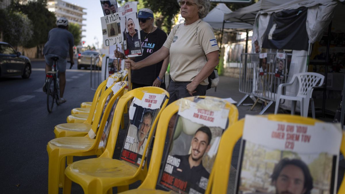 Women hold signs with photographs of hostages who were kidnapped during the Oct. 7 Hamas cross-border attack in Israel
