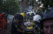 Rescue workers and police officers carry an injured person by a stretcher to an ambulance from a building which was destroyed by a Russian airstrike in Kharkiv, Ukraine.