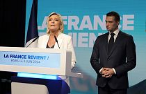 Marine Le Pen, leader de l'extrême droite française, s'exprime tandis que Jordan Bardella, président du Rassemblement national d'extrême droite français, l'écoute au siège du parti lors de la soirée électorale, dimanche, 