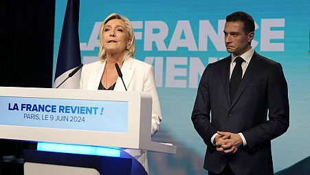 French far-right leader Marine Le Pen speaks as Jordan Bardella, president of the French far-right National Rally, listens at the party election night headquarters on Sunday, 