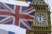 A British flag flies over a tourist kiosk on Westminster Bridge with the Elizabeth Tower, which contains the bell known as Big Ben, in the background, London, December 13 2023