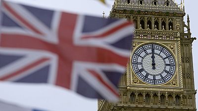 A British flag flies over a tourist kiosk on Westminster Bridge with the Elizabeth Tower, which contains the bell known as Big Ben, in the background, London, December 13 2023