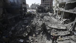 فلسطينيون ينظرون إلى آثار القصف الإسرائيلي في مخيم النصيرات للاجئين، قطاع غزة، في 8 يونيو 2024. 