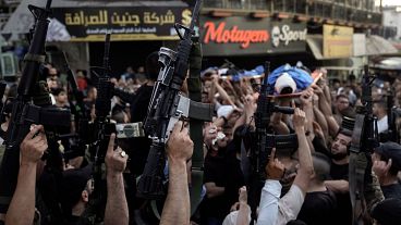 فلسطينيون يرفعون أسلحتهم خلال تشييع جنازة في جنين في الضفة الغربية المحتلة. 2024/06/06
