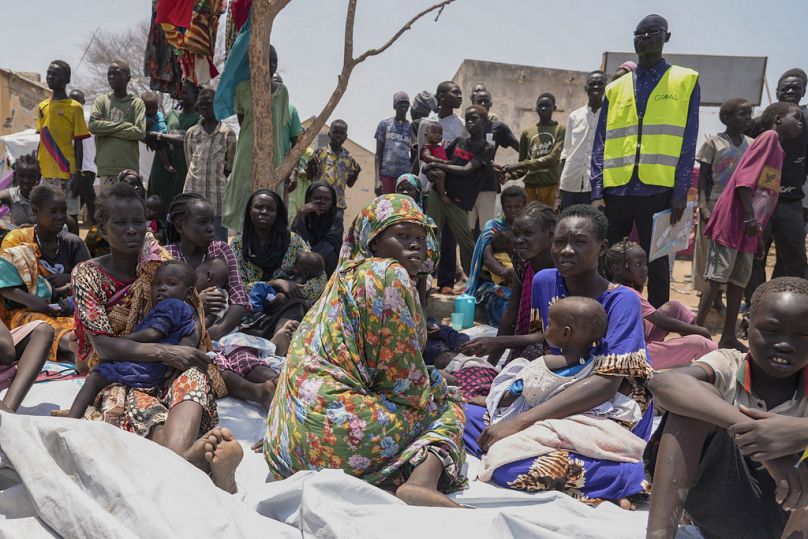 Civilians who fled from Sudan sit outside a nutrition clinic at a transit center in Renk, South Sudan, May 2023